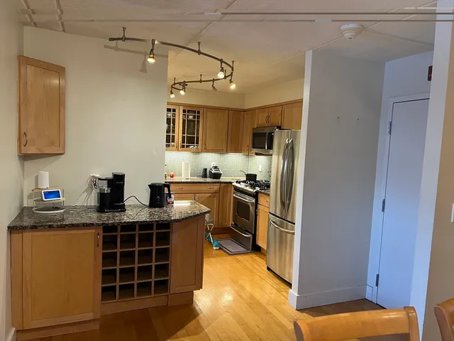 a kitchen with kitchen island granite countertop a sink window and stainless steel appliances