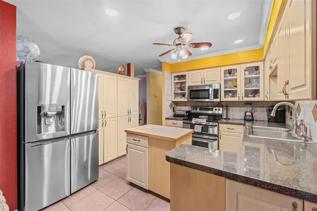 a kitchen with stainless steel appliances granite countertop a sink a stove and a refrigerator