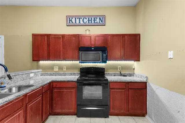 a kitchen with kitchen island granite countertop stainless steel appliances a stove top oven and cabinets