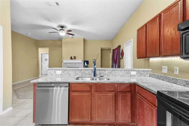 a kitchen with kitchen island granite countertop a sink stainless steel appliances cabinets and furniture