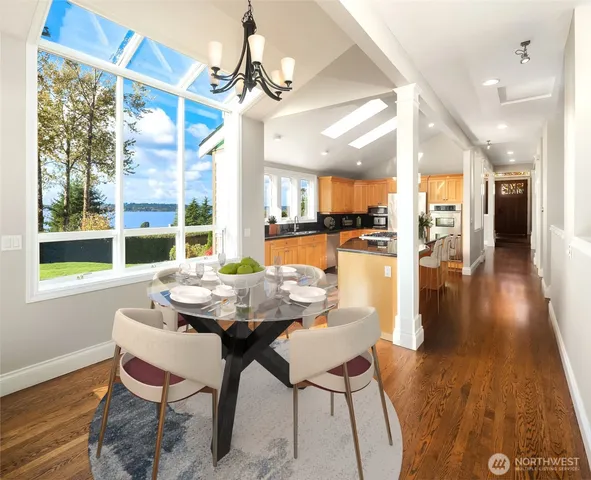 a dining room with wooden floor a chandelier a wooden table and chairs