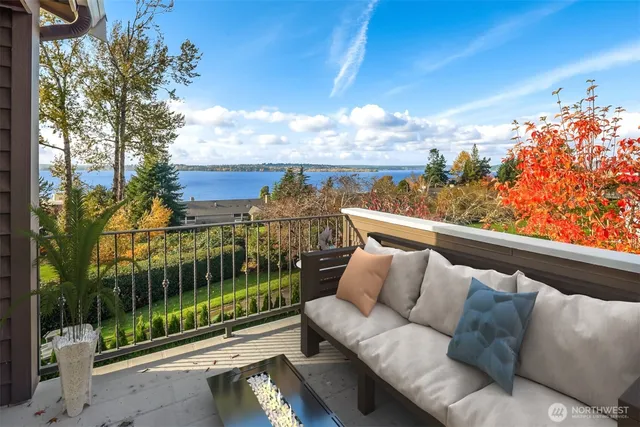 a roof deck with couch and wooden fence