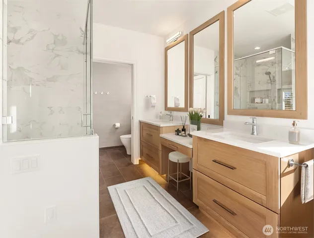 a spacious bathroom with a double vanity sink a toilet and a tub