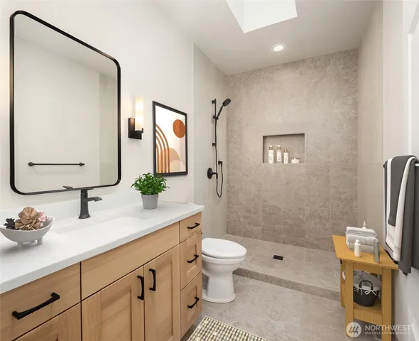 a bathroom with a granite countertop sink mirror vanity and toilet