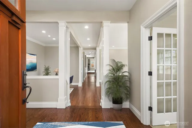 a view of a hallway with wooden floor and a living room