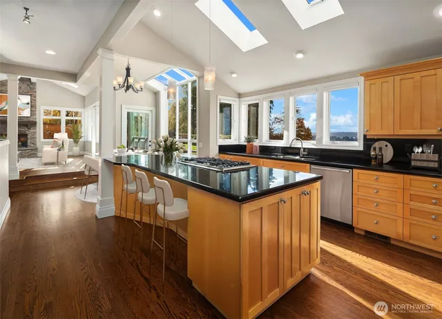 a large kitchen with kitchen island granite countertop a large window and stainless steel appliances