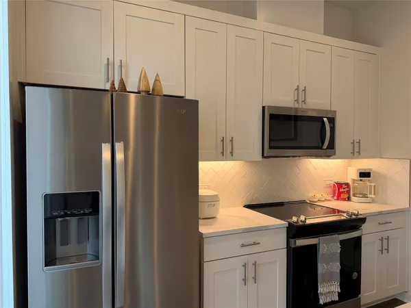 a kitchen with stainless steel appliances granite countertop a refrigerator and a stove top oven