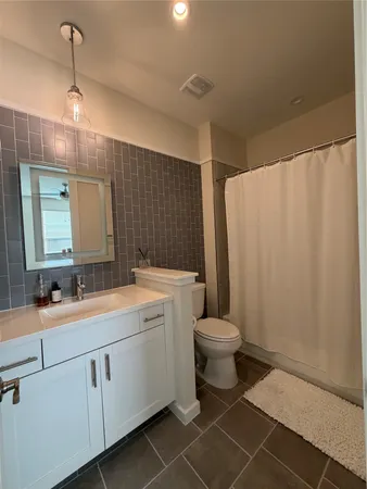 a bathroom with a double vanity sink toilet and a mirror