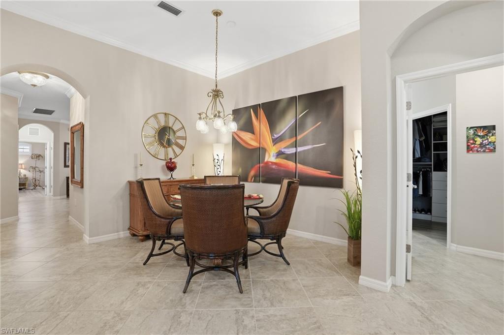 10505 Casella Way, Unit 202 Fort Myers, FL 33913 - Photo 16 of 50 a view of a dining room and livingroom with furniture wooden floor a rug a painting and a chandelier
