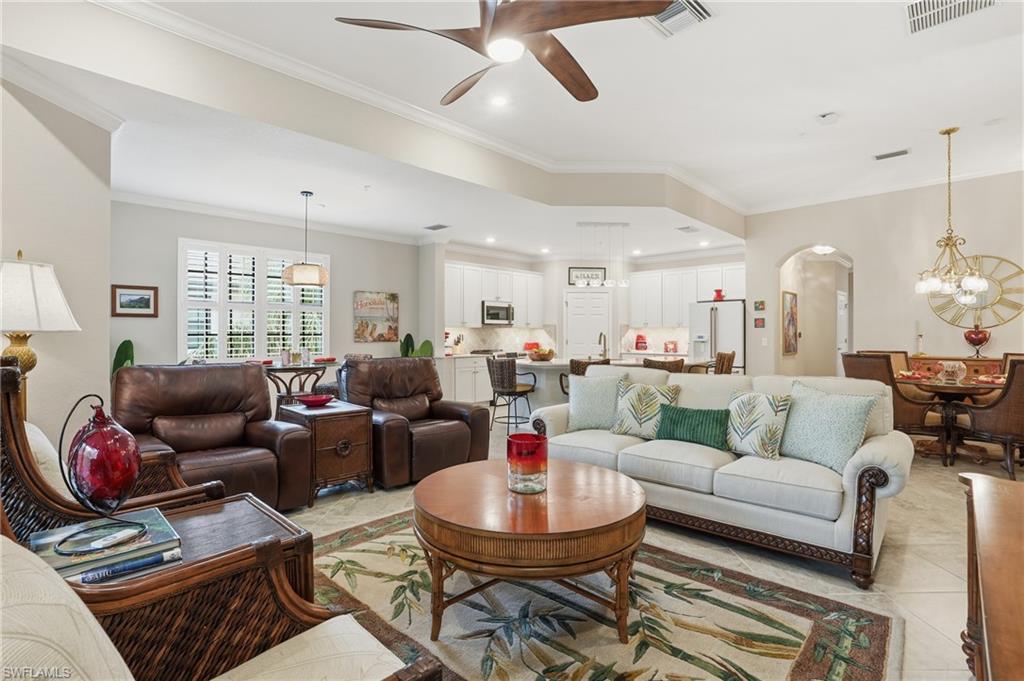 10505 Casella Way, Unit 202 Fort Myers, FL 33913 - Photo 18 of 50 a living room with furniture a fireplace and a chandelier