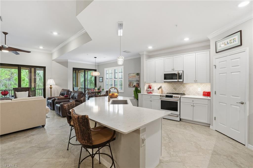 10505 Casella Way, Unit 202 Fort Myers, FL 33913 - Photo 26 of 50 a kitchen with a stove a refrigerator and a dining table