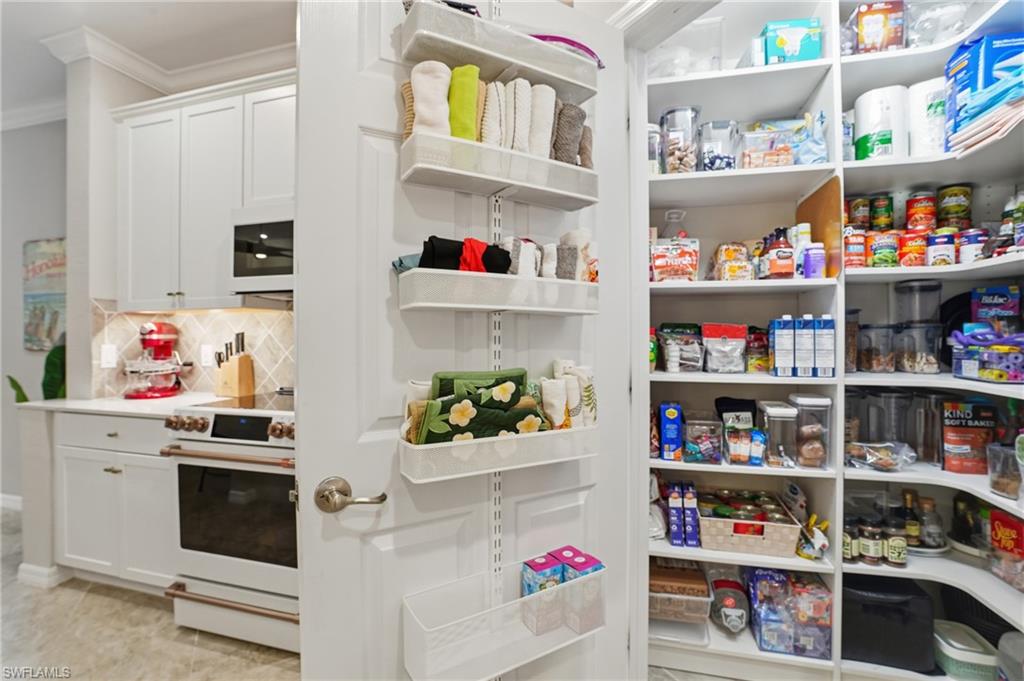 10505 Casella Way, Unit 202 Fort Myers, FL 33913 - Photo 29 of 50 a cabinet with white and a kitchen space and lots of clutter
