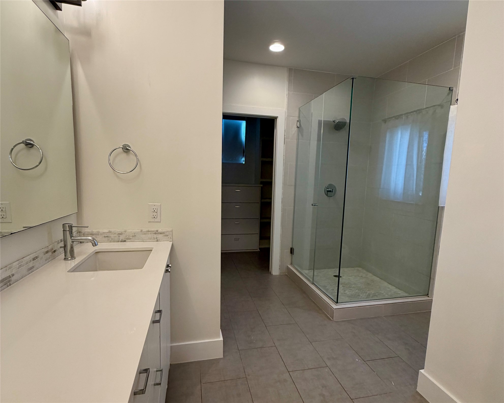 1515 Hether Street, Unit B Austin, TX 78704 - Photo 9 of 30 A well-lit bathroom with a glass-enclosed shower and a spacious vanity.