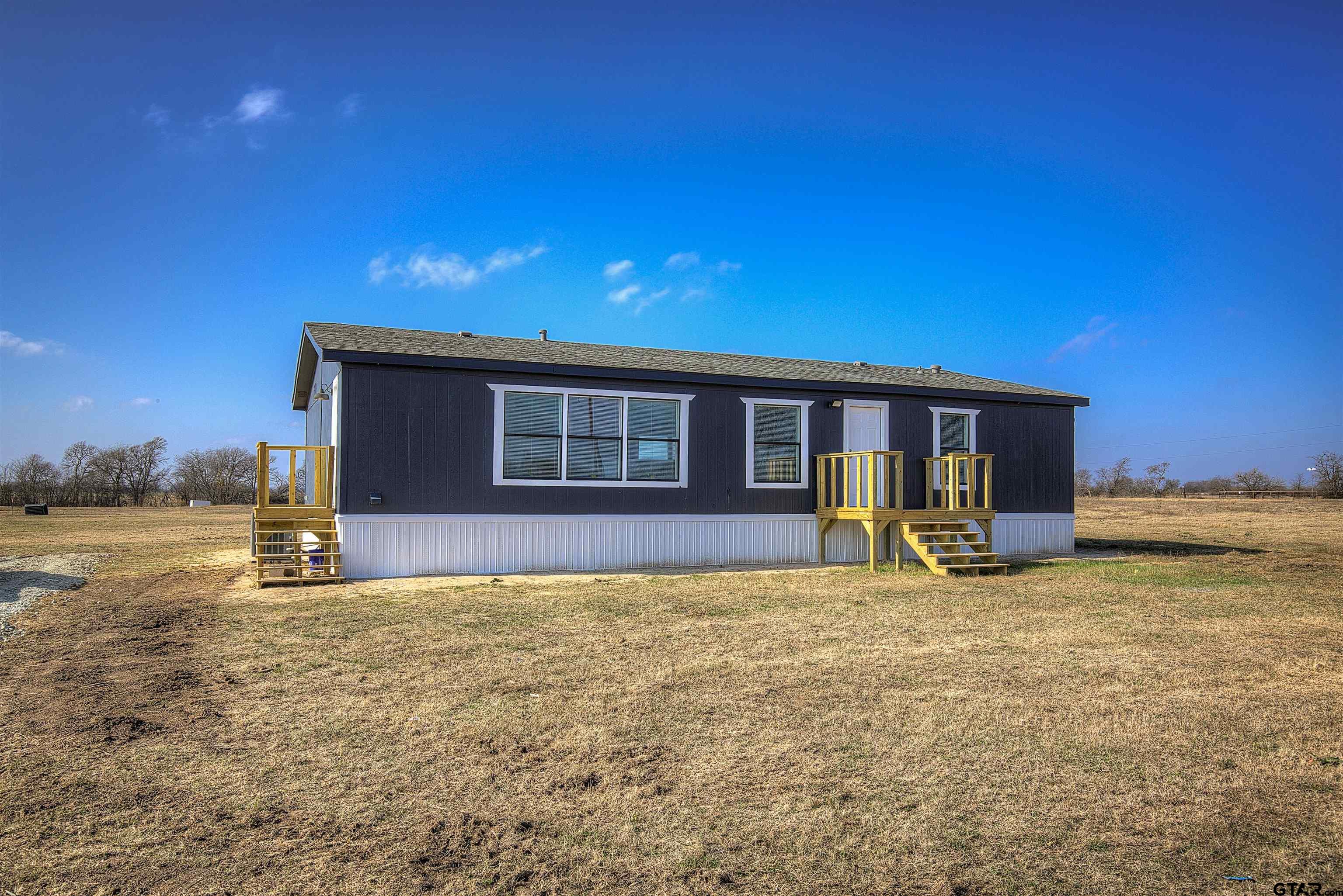 a view of an house with backyard space and balcony