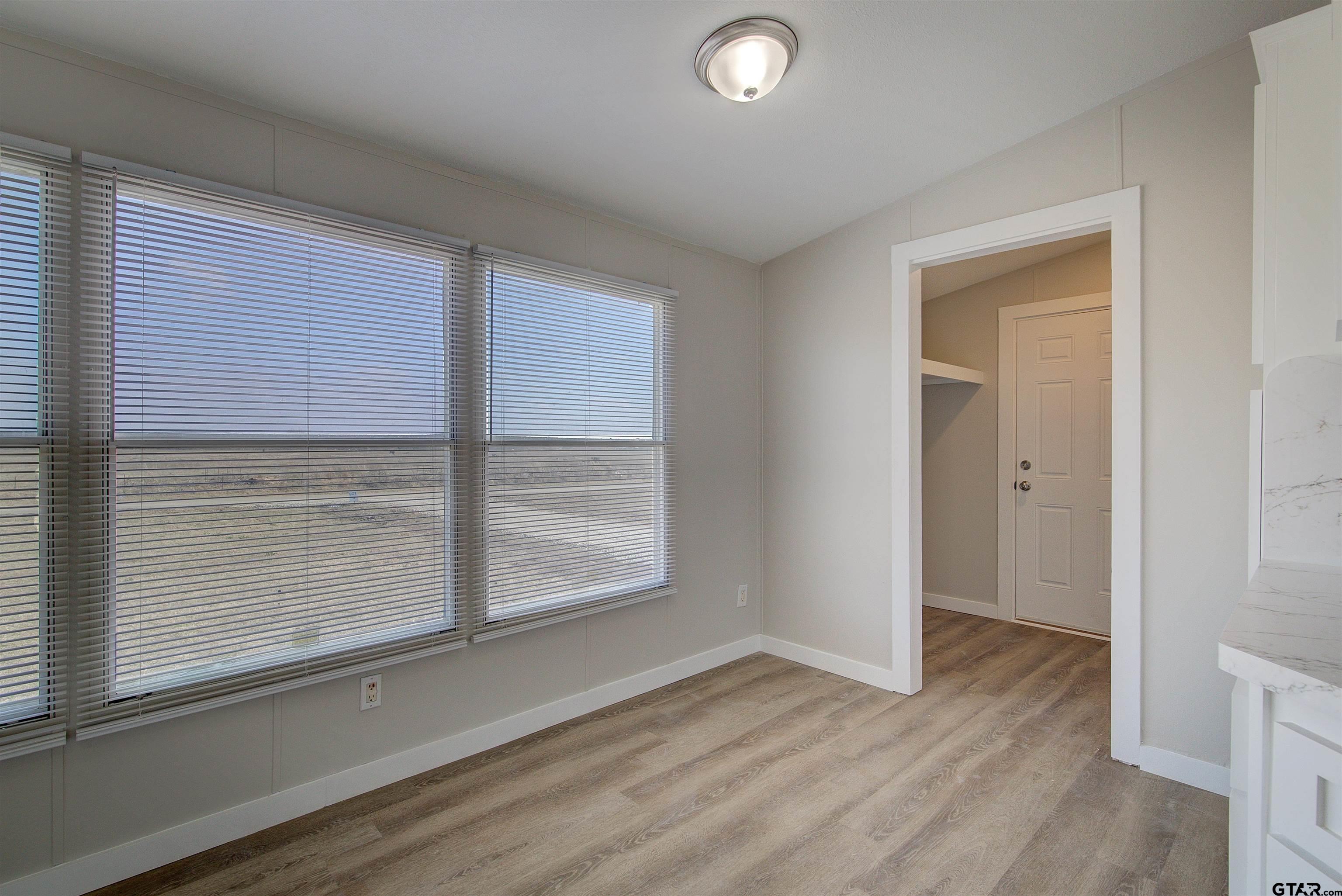1945 Co Road Sulphur Springs, TX 75482 - Photo 11 of 29 a view of an empty room with wooden floor and a window