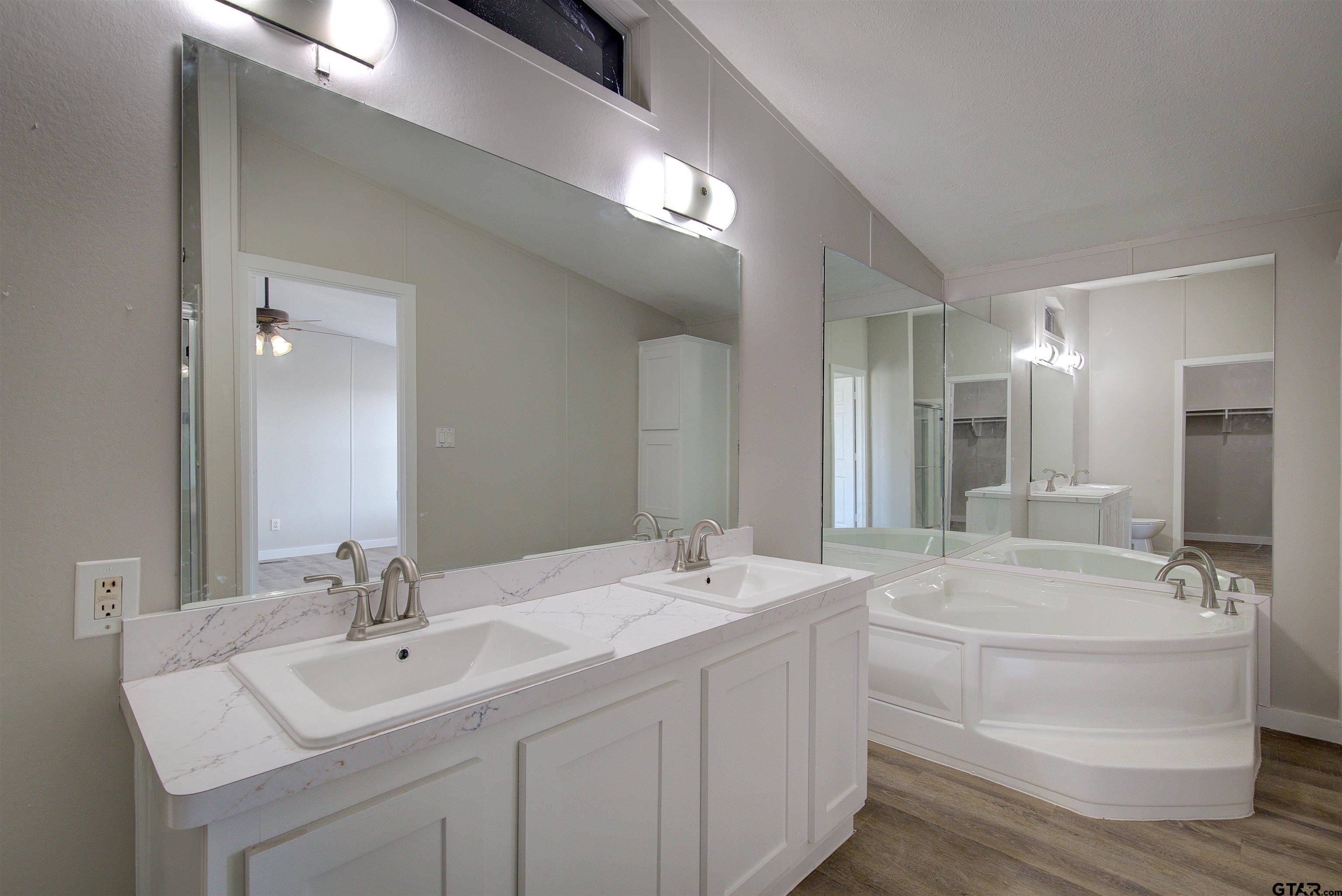1945 Co Road Sulphur Springs, TX 75482 - Photo 16 of 29 a bathroom with a double vanity sink mirror and bathtub
