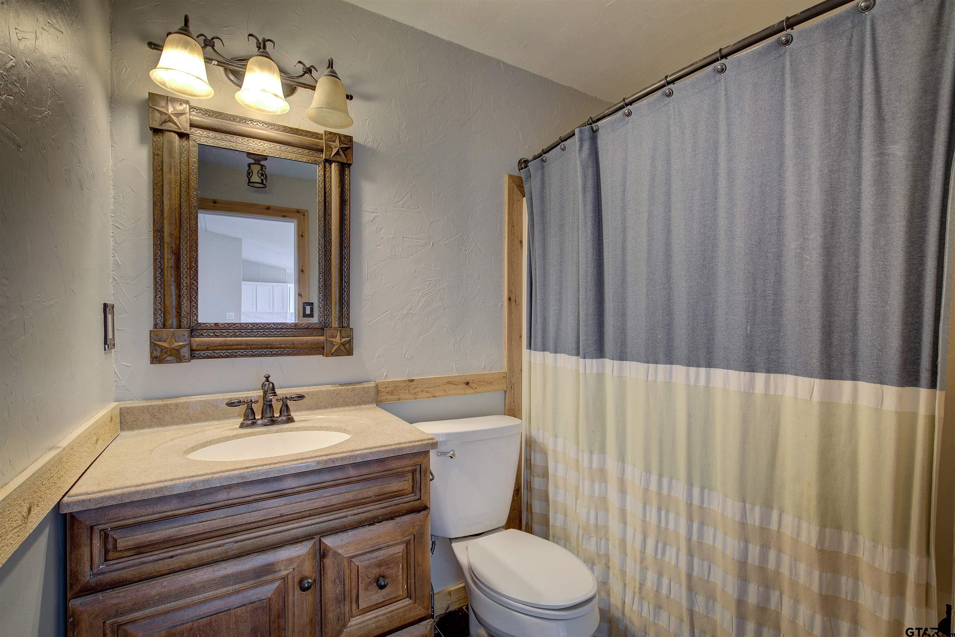 1945 Co Road Sulphur Springs, TX 75482 - Photo 21 of 29 a bathroom with a sink a toilet and mirror