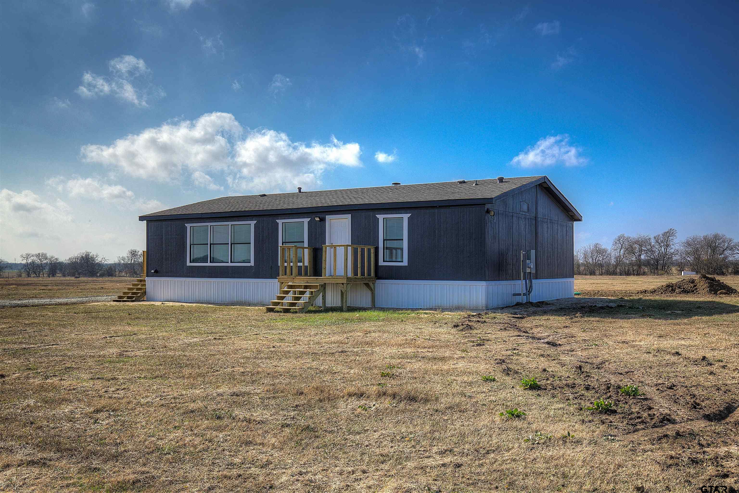 1945 Co Road Sulphur Springs, TX 75482 - Photo 25 of 29 a view of a house with backyard porch and wooden fence