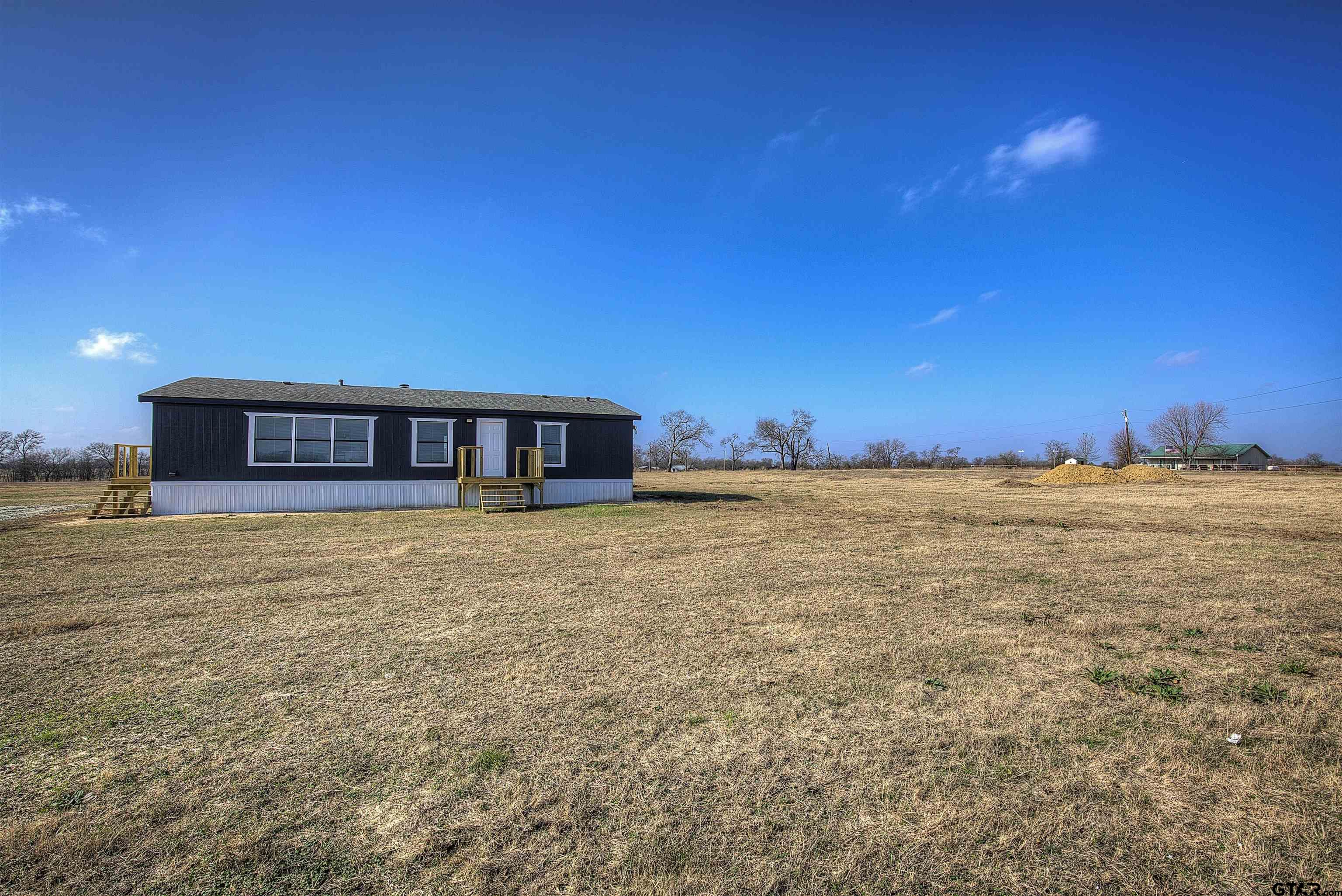 1945 Co Road Sulphur Springs, TX 75482 - Photo 3 of 29 a view of a house with a yard