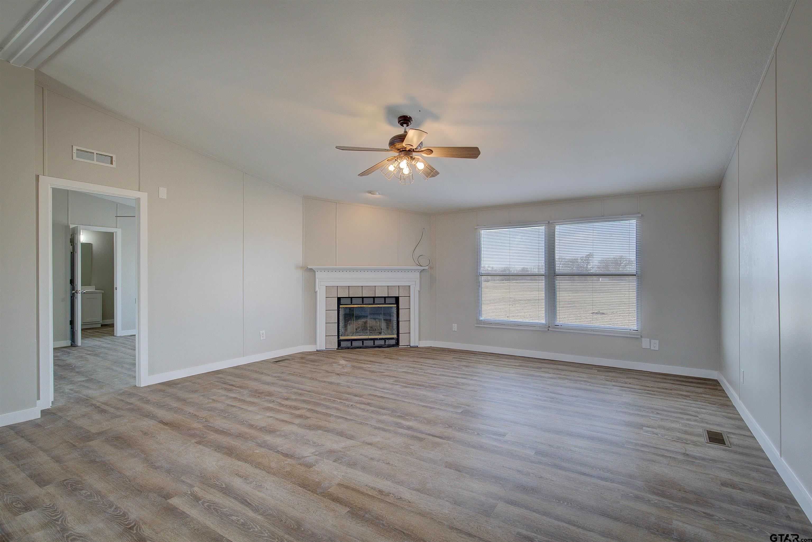 1945 Co Road Sulphur Springs, TX 75482 - Photo 5 of 29 wooden floor in an empty room with a window
