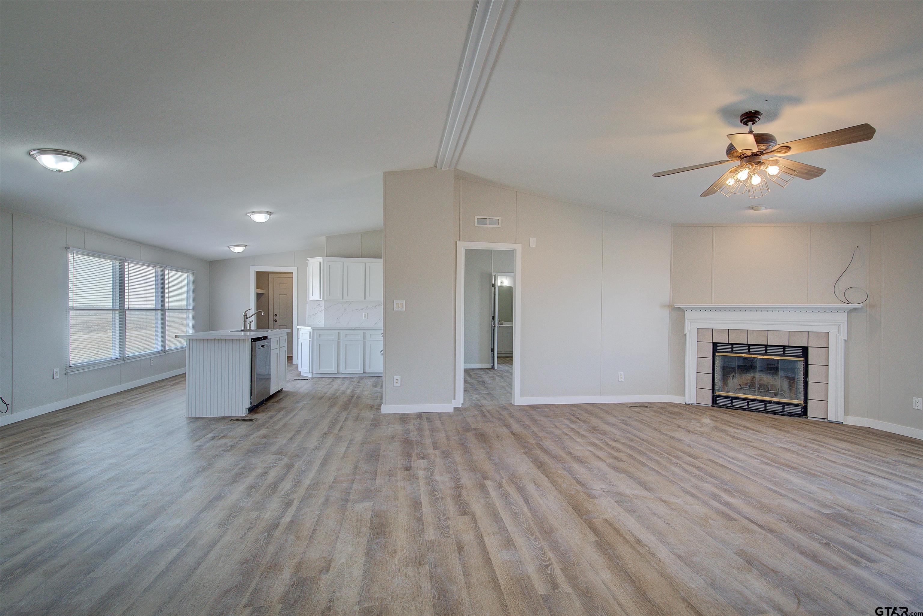 1945 Co Road Sulphur Springs, TX 75482 - Photo 6 of 29 a view of empty room with wooden floor and fireplace
