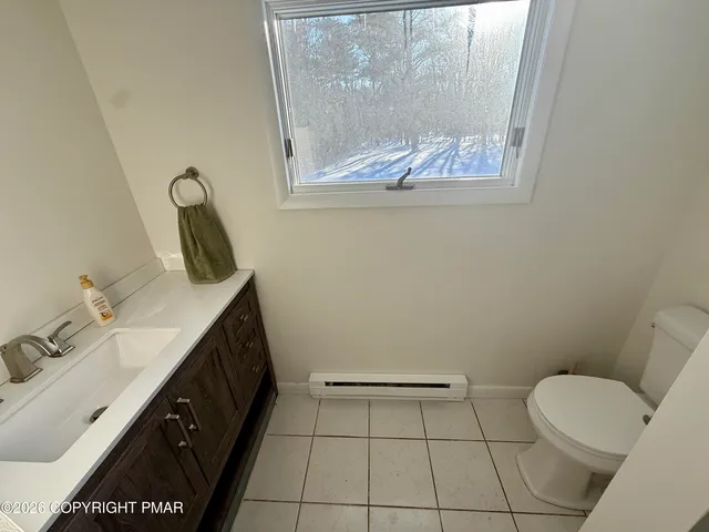 a bathroom with a granite countertop sink a toilet and a mirror