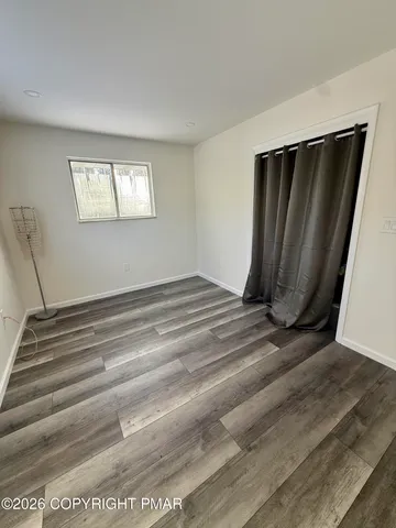 a view of a closet area with wooden floor