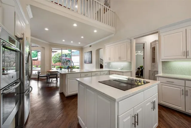 a kitchen that has a sink a stove and chairs