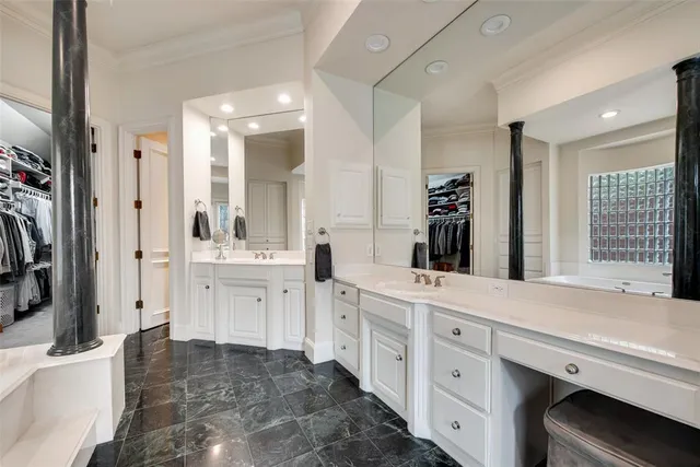 a spacious en suite bathroom with a double vanity sink a large mirror and a shower