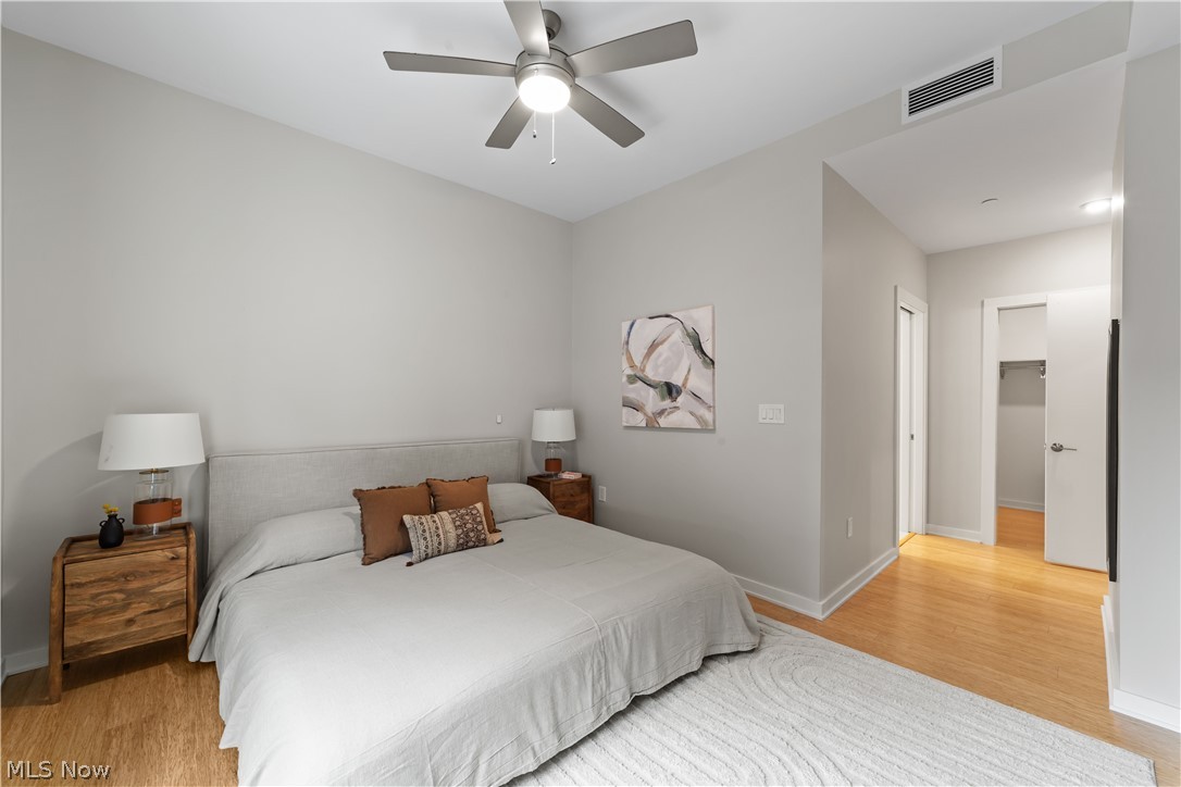 2044 Random Road, Unit 101 Cleveland, OH 44106 - Photo 17 of 44 Bedroom featuring a walk in closet, ceiling fan, light hardwood / wood-style floors, and a closet
