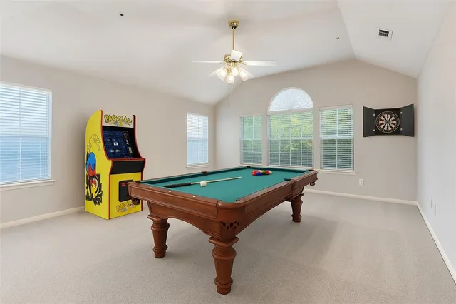 an empty room with a chandelier fan and windows