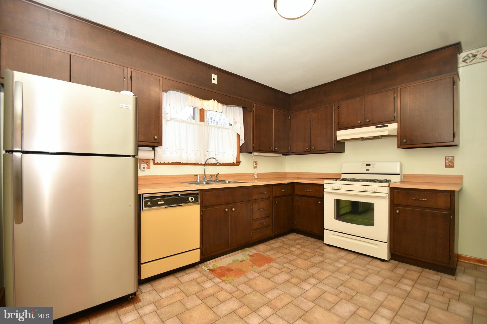9412 Dawnvale Road Baltimore, MD 21236 - Photo 11 of 28 a kitchen with stainless steel appliances granite countertop a refrigerator a sink dishwasher a stove with wooden cabinets