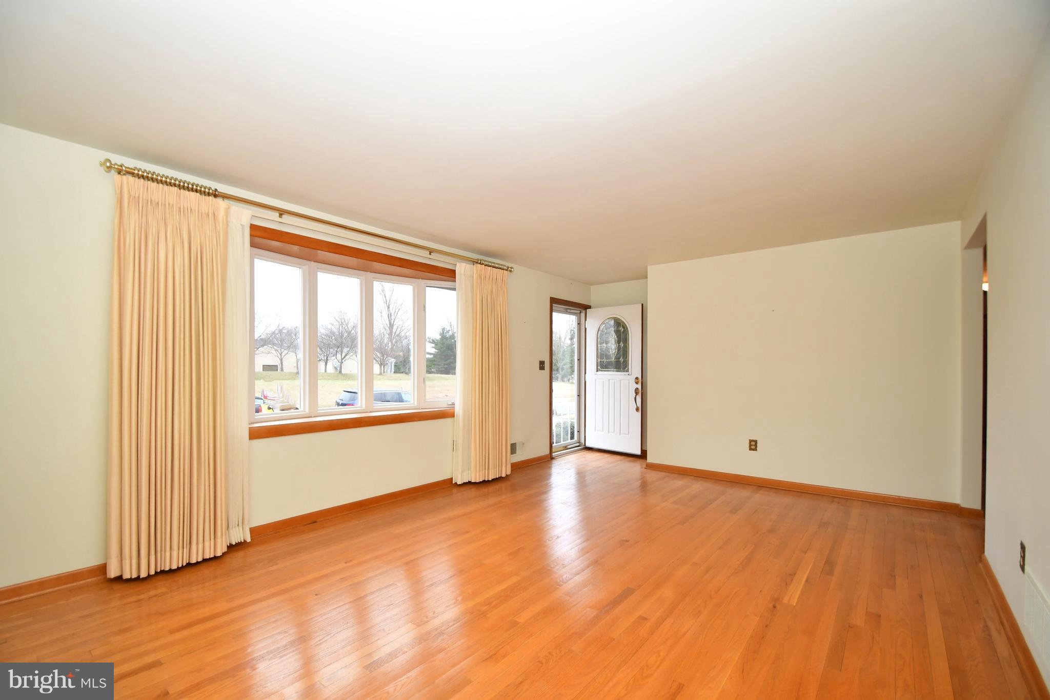 9412 Dawnvale Road Baltimore, MD 21236 - Photo 5 of 28 an empty room with wooden floor and windows