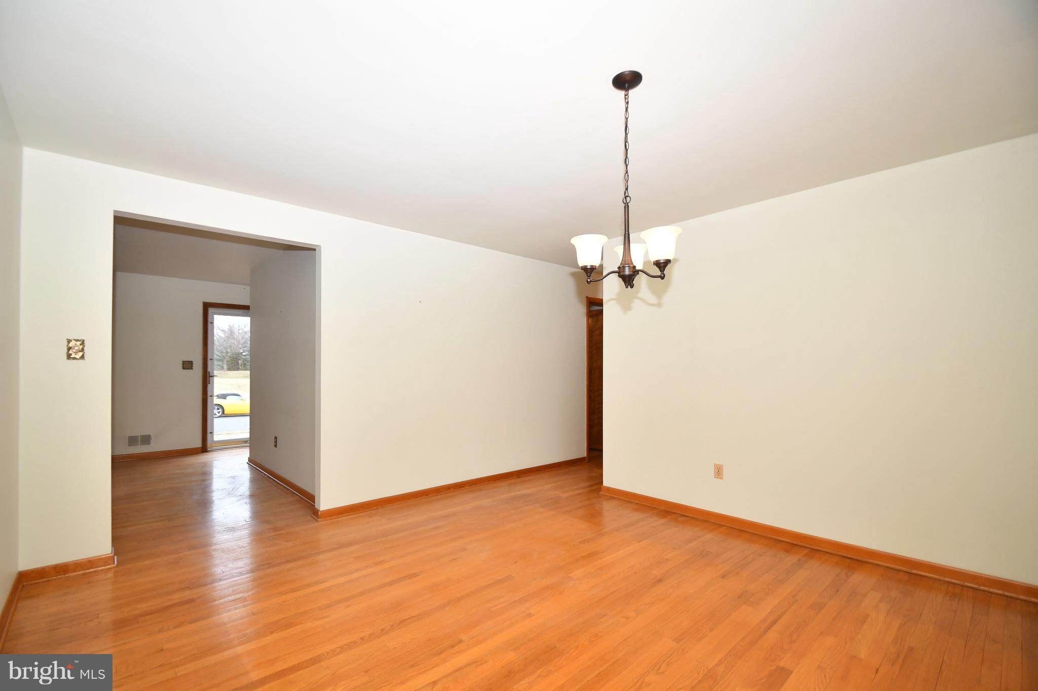 9412 Dawnvale Road Baltimore, MD 21236 - Photo 8 of 28 a view of a room with wooden floor and a ceiling fan