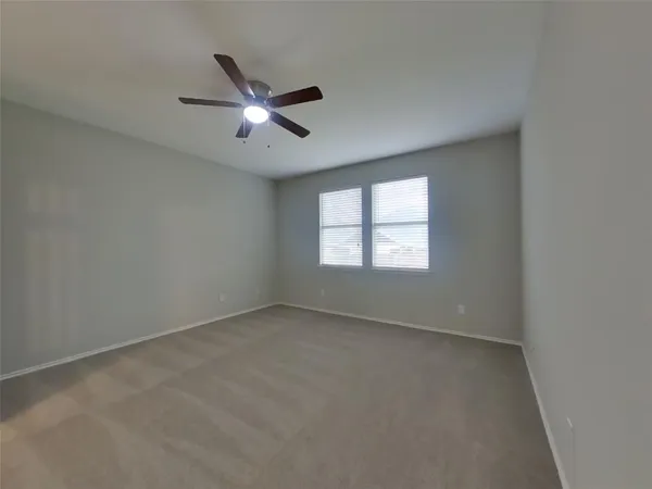 an empty room with a window and a fan