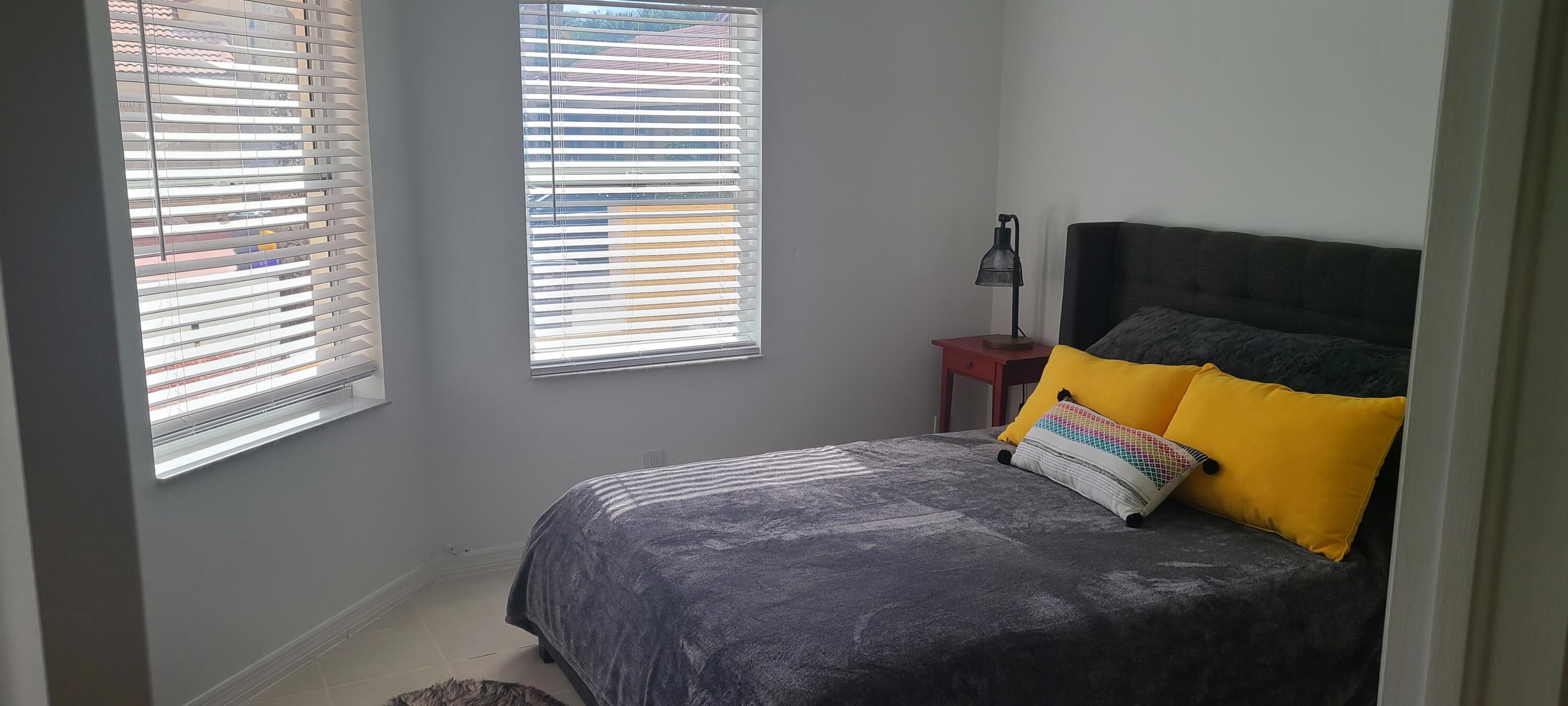 11105 Rios Road Boca Raton, FL 33498 - Photo 15 of 31 a bed sitting in a bedroom next to a window