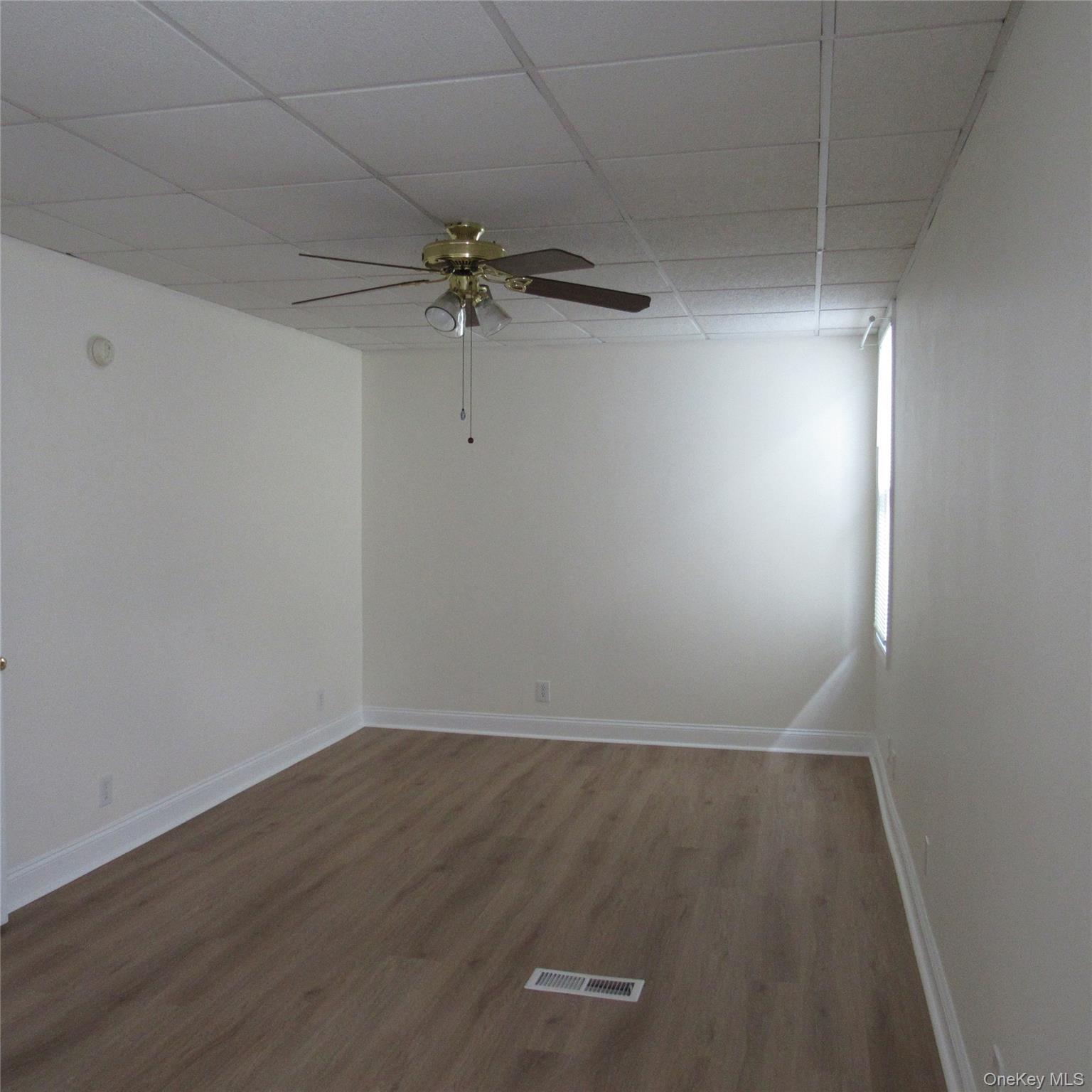 35 Taylor Avenue, Unit 2 Poughkeepsie, NY 12601 - Photo 9 of 19 Unfurnished bedroom featuring a paneled ceiling, ceiling fan, and dark wood finished floors
