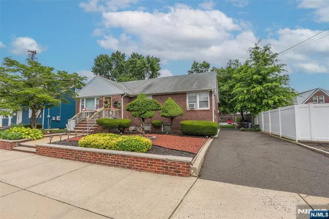a front view of a house with a yard and potted plants