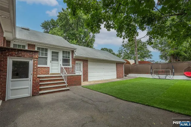 a view of a house with a yard and large tree