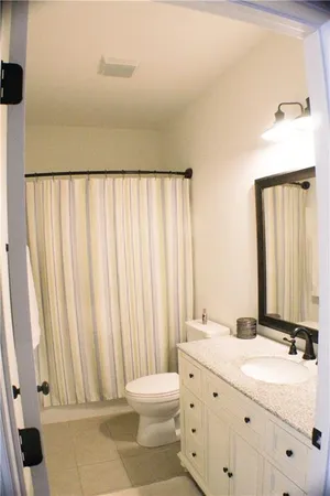 a bathroom with a double vanity sink mirror and toilet