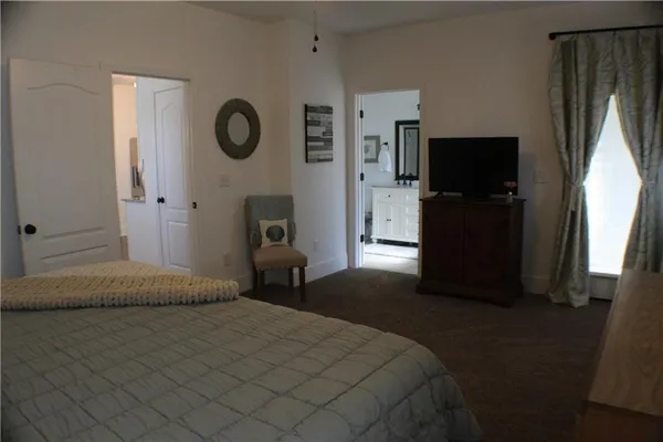 a bedroom with a bed and a flat tv screen on the dresser
