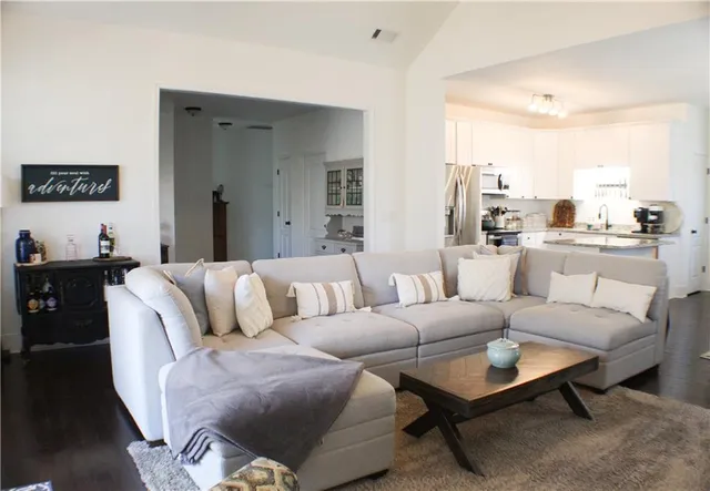 a living room with furniture kitchen view and a window