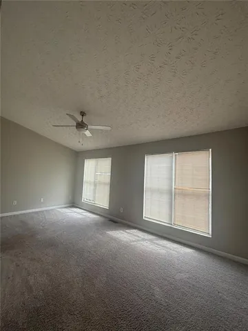 an empty room with windows and ceiling fan view