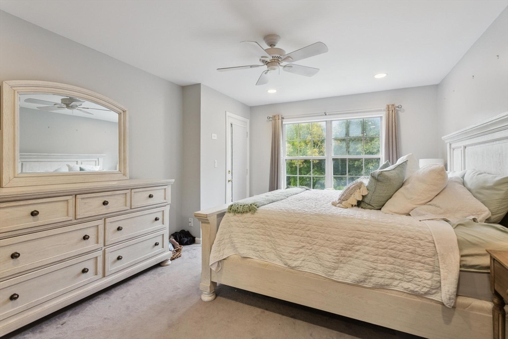 707 Gazebo Circle, Unit 707 Reading, MA 01867 - Photo 20 of 41 a bedroom with a large bed and a mirror on dresser