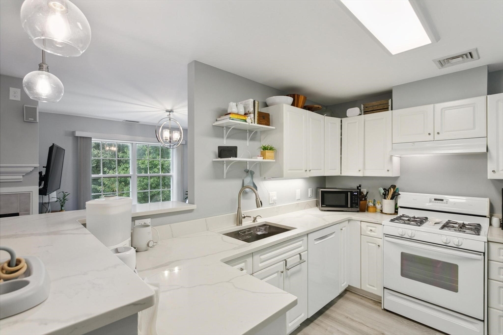707 Gazebo Circle, Unit 707 Reading, MA 01867 - Photo 7 of 41 a kitchen with a stove a sink and a refrigerator