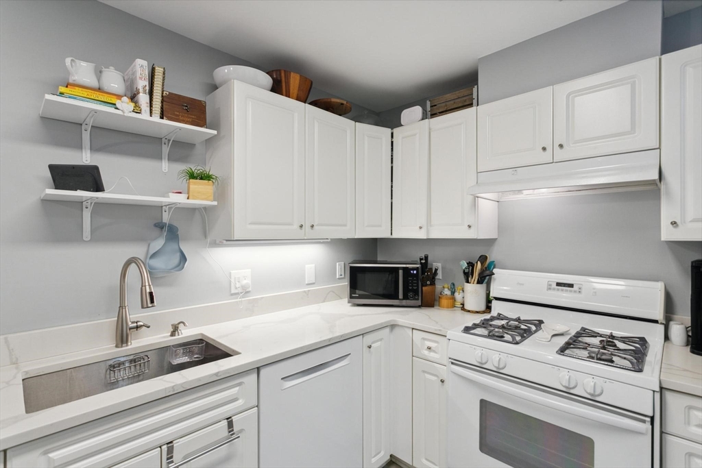 707 Gazebo Circle, Unit 707 Reading, MA 01867 - Photo 8 of 41 a kitchen with white cabinets and appliances