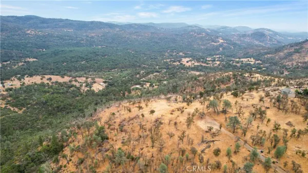 a view of a dry yard with mountains in the background