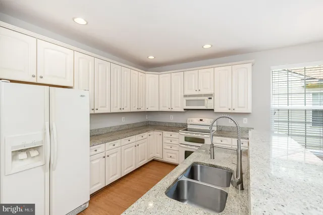 a kitchen with granite countertop a sink stainless steel appliances and cabinets