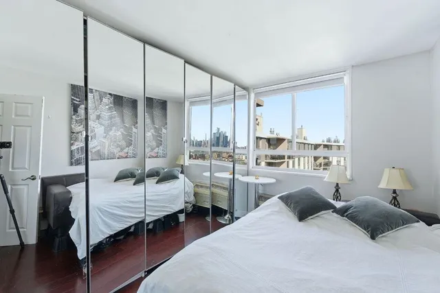 a bedroom with two beds and large window