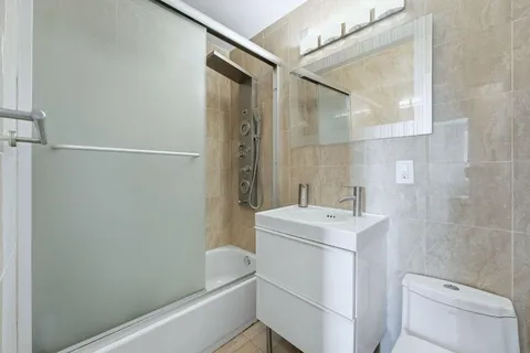 a bathroom with a sink a toilet a shower and a mirror